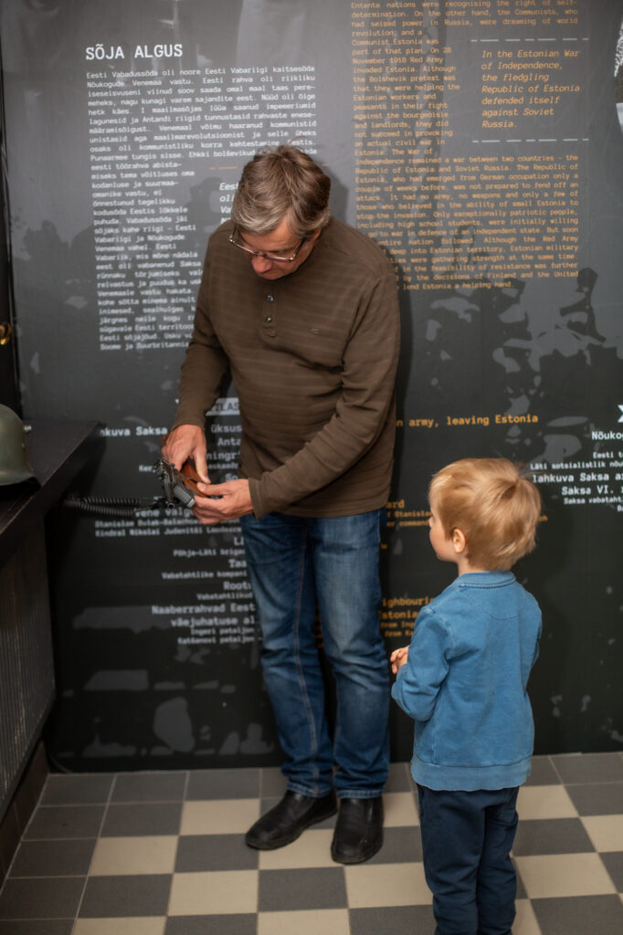 Vanaisa ja lapselaps Eesti sõjamuuseumis relvadega tutvumas